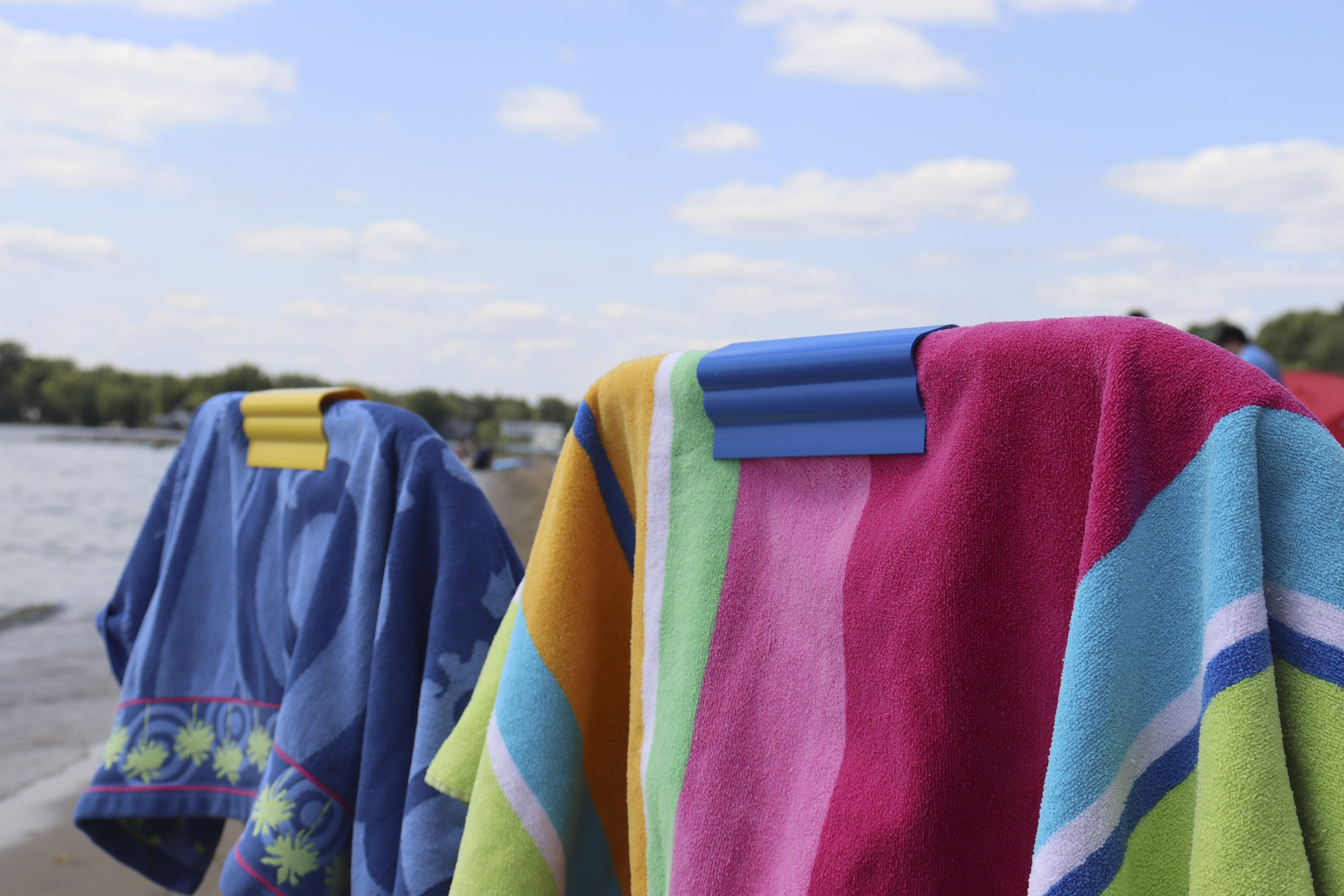 Colorful beach towels draped by lakeside