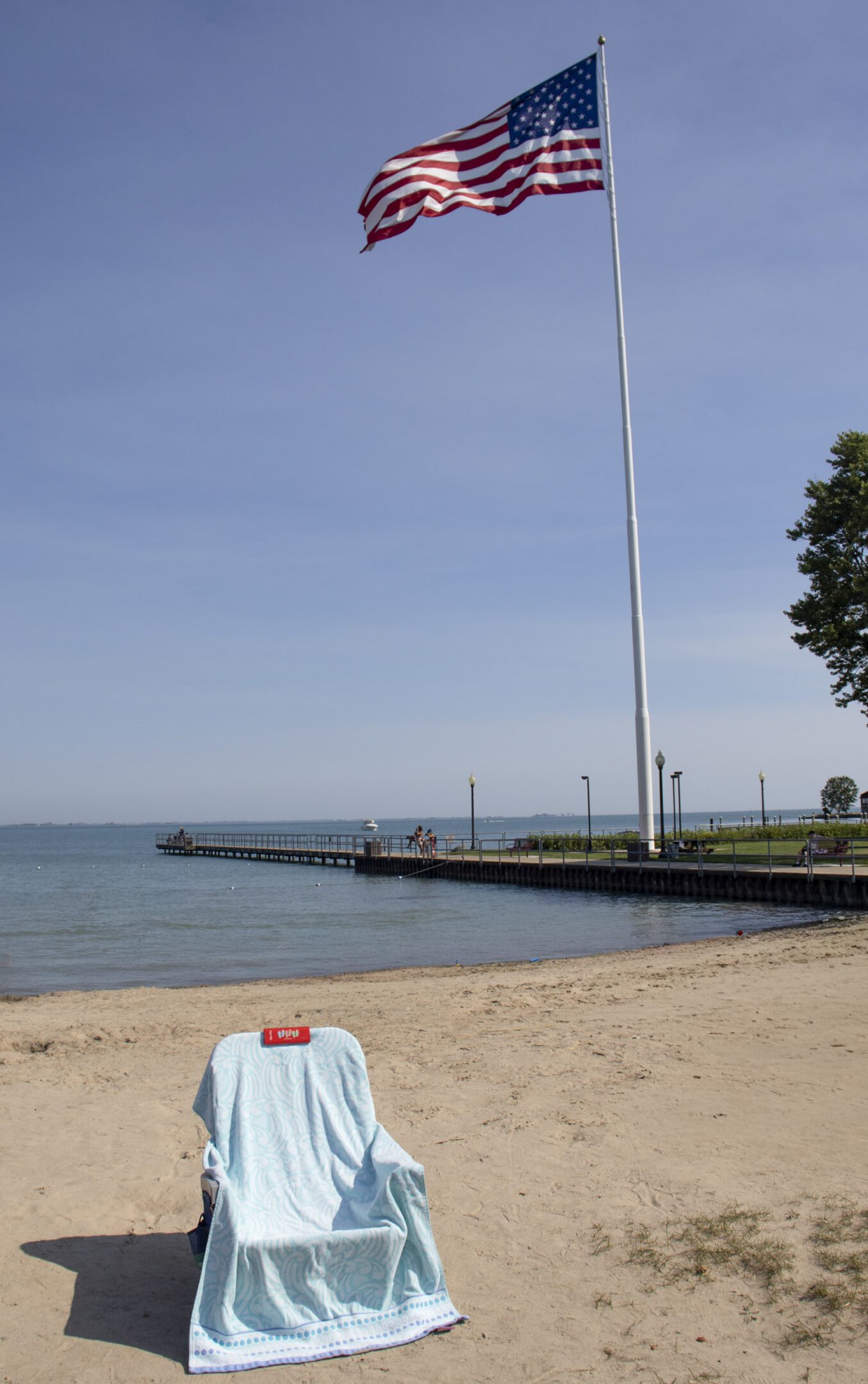 Sandy beach with flag and chair